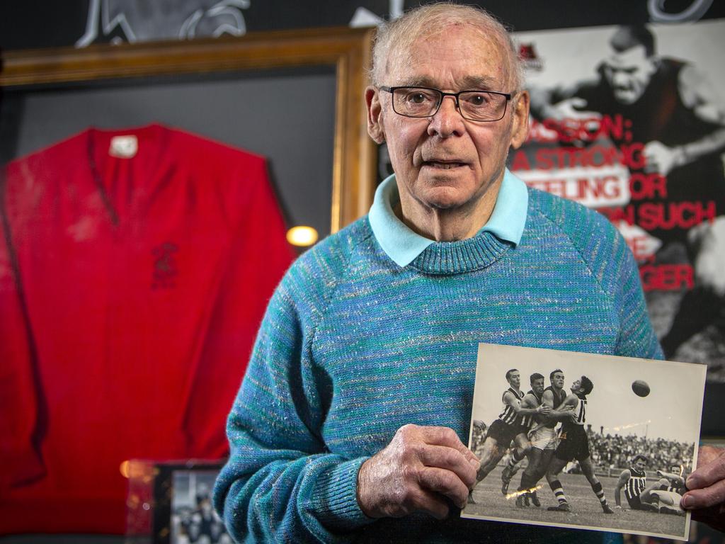 Ted Kerley holds a photograph of late brother Neil in action for West Adelaide. Picture: Emma Brasier