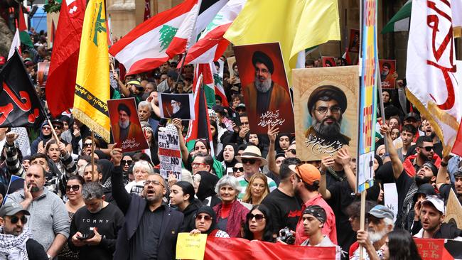 People hold up pictures of Hezbollah leader Hassan Nasrallah and the Hezbollah flag at a protest at Town Hall in Sydney on September 29. Picture: Damian Shaw/NewsWire