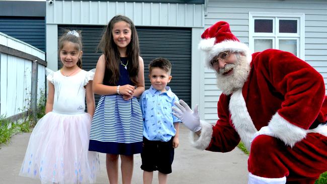 Santa Claus visits Leila, 7, Jasmine, 5, and Ali Mohamad during their home quarantine. Picture: HEIDI ROBNIK.