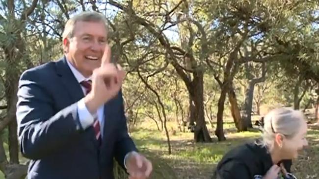 Mr Whitby holds up his finger for the cameras, laughing off the incident before Kaya's embarrassed handler. Picture: Seven News.