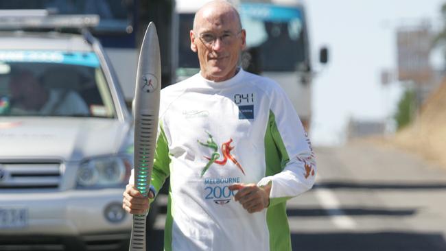 Clyde Sefton runs with the Queen's Baton.