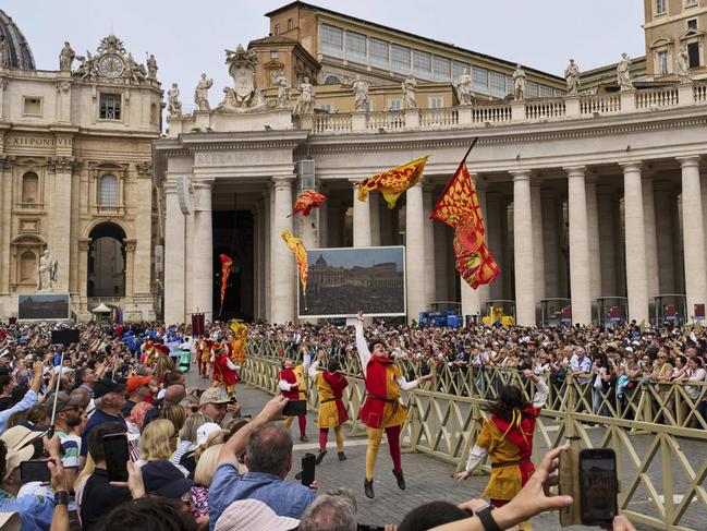 Flag wavers perform before Pope Leo XIV appears at the central balcony. AP Photo