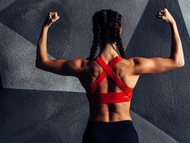 Back view portrait of a fitness woman showing biceps.