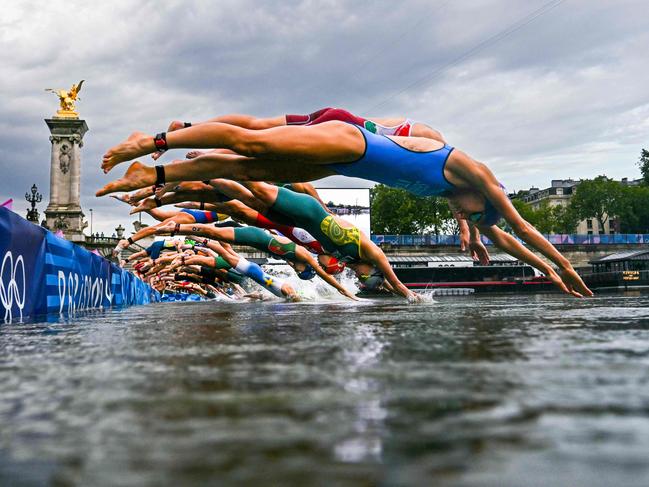 (FILES) Athletes compete in the swimming race in the Seine during the women's individual triathlon at the Paris 2024 Olympic Games in central Paris on July 31, 2024. Paris Olympics organisers have cancelled training for triathletes in the River Seine again because of poor water quality, leading to more uncertainty over whether the mixed relay will go ahead as planned on August 5, 2024. (Photo by MARTIN BUREAU / POOL / AFP)