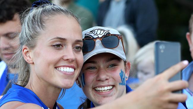 Kaitlyn Ashmore takes a selfie with a happy North Melbourne fan.