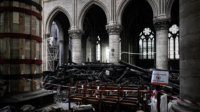 A worker stands on scaffolding near to damages and rubble during preliminary work in the Notre Dame de Paris Cathedral one month after it sustained major fire damage. Picture: Philippe Lopez/AFP