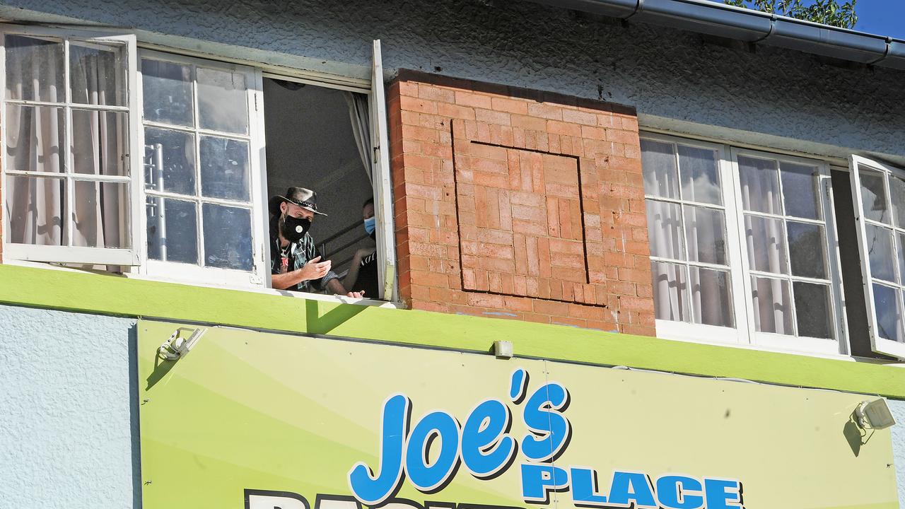 A person inside Joe’s Place Backpackers looks out a window after the facility was shut because of a positive Covid-19 case. Picture: John Gass