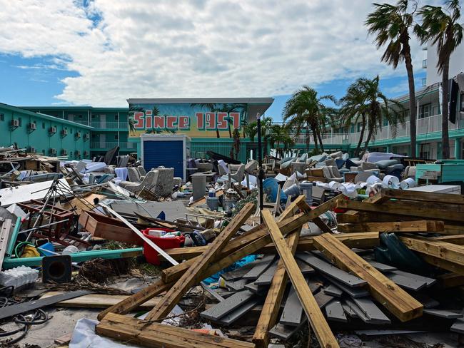 TOPSHOT - Debris is seen in front of the Thunderbird Beach Resort in the aftermath of Hurricane Milton in Treasure Island, Florida, on October 11, 2024. The death toll from Hurricane Milton has risen to at least 16, officials in Florida said October 11, 2024, and millions were still without power as residents began the painful process of piecing their lives back together. More than two million households and businesses were still without power, officials said, and some areas in the path that the monster storm blasted through the state remained flooded. (Photo by GIORGIO VIERA / AFP)