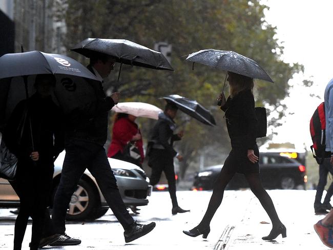 City workers make their way through the cold rain too their dry warm office buildings Melbourne.  Picture: Nicole Garmston