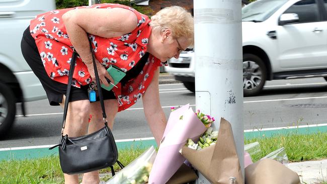 A woman leaves flowers at the corner of Vinna Rd and Finucane Rd, Alexandra Hills. Picture: John Gass