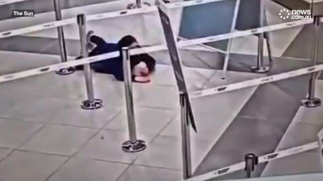 Woman crawls under airport security barrier