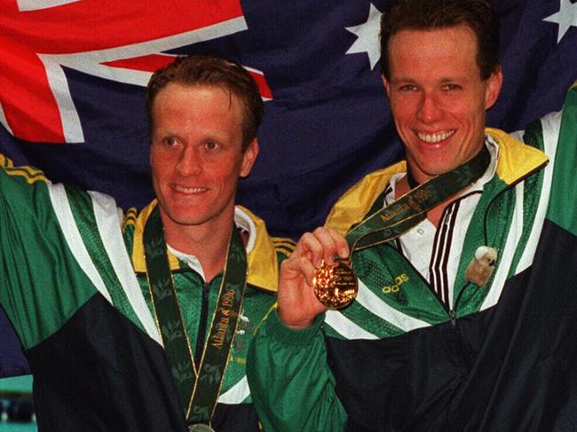 Aust swimmer Kieren Perkins (r) with Daniel Kowalski (l) holding up Australian flag and wearing their olympic 1500m gold and silver swimming medals.  atlanta games  /Oympic/Games/1996