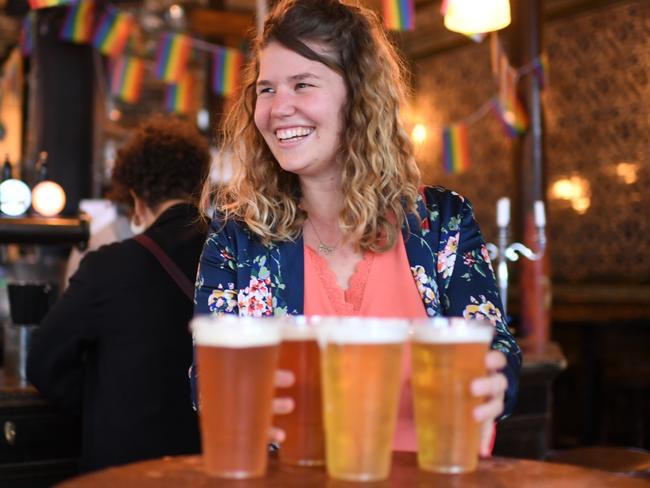 Customers leave with pints of beer for takeaway at The Ten Bells pub in east London on June 27, 2020. - The pub serves drinks for takeaway to maintain social distancing and coronavirus lockdown regulations. Prime Minister Boris Johnson wants pubs and restaurants to be buzzing in the curtailed summer season, despite continued social distancing rules and restrictions. (Photo by DANIEL LEAL-OLIVAS / AFP)