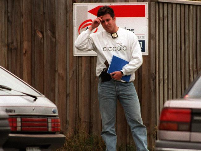 A detective guards the body of one of the two dead bandits after the shooting.