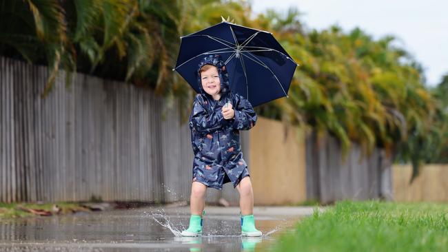 The start of summer has seen rainy weather return to Far North Queensland. Cairns youngster Noah Millard, 4, enjoys the return of the wet weather, dressing up in his raincoat and gumboots, and jumping into rain puddles outside his Smithfield home. Picture: Brendan Radke