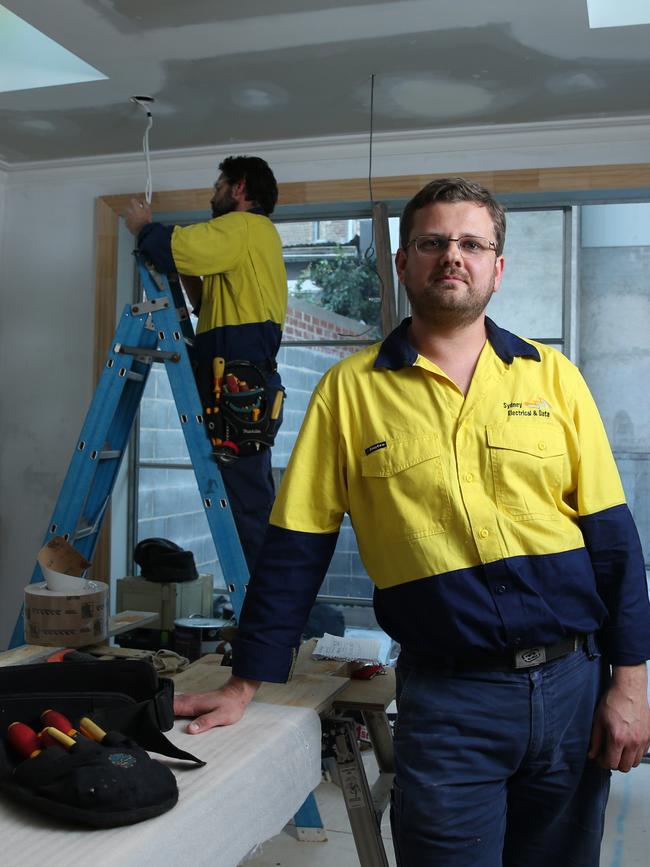 Electricians Andrew Hardingham (right) Randall Smith work on a residential renovation in Sydney’s Surry Hills. Picture: Britta Campion