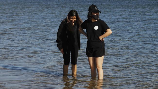 People wearing face masks enjoy the sun at Melbourne’s St Kilda beach at the weekend. Picture: Daniel Pockett/Getty Images