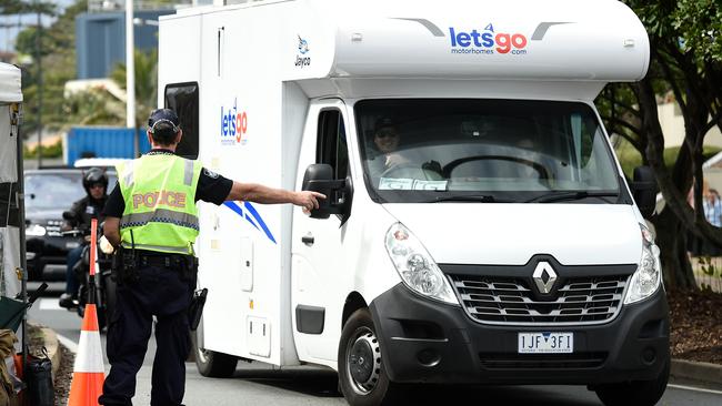 Police directing Victorian licence plate drivers into the side street at the Griffith Street checkpoint at Coolangatta. (Photo by Matt Roberts/Getty Images).