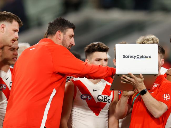 MELBOURNE, AUSTRALIA - JUNE 04: Dean Cox, Game Strategy & Ruck Coach of the Swans instructs players on a laptop during the 2022 AFL Round 12 match between the Melbourne Demons and the Sydney Swans at the Melbourne Cricket Ground on June 04, 2022 in Melbourne, Australia. (Photo by Michael Willson/AFL Photos via Getty Images)