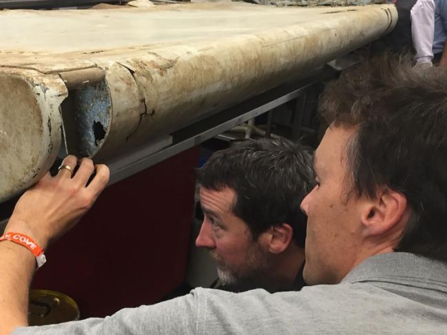 An undated handout photo released by the Australian Transport Safety Board (ATSB) and received on September 15, 2016, shows officials inspecting a large piece of debris found in Tanzania recently which has been confirmed as a part of a wing flap from missing Malaysia Airlines passenger jet MH370.  The outboard flap is the fifth piece of the plane to be identified by experts in Canberra since the first bit of debris  from MH370 -- a two-metre (almost seven-foot) wing part known as a flaperon -- was found on the French Indian Ocean island of Reunion in July 2015. / AFP PHOTO / ATSB / Handout / RESTRICTED TO EDITORIAL USE - MANDATORY CREDIT 