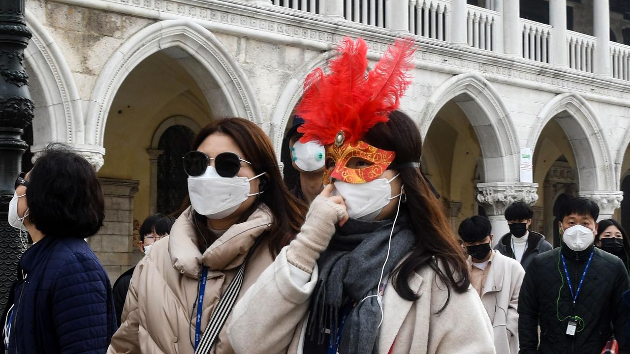 Tourists were spotted wearing protective face masks and Carnival masks in Venice. Picture: AFP/ANDREA PATTARO