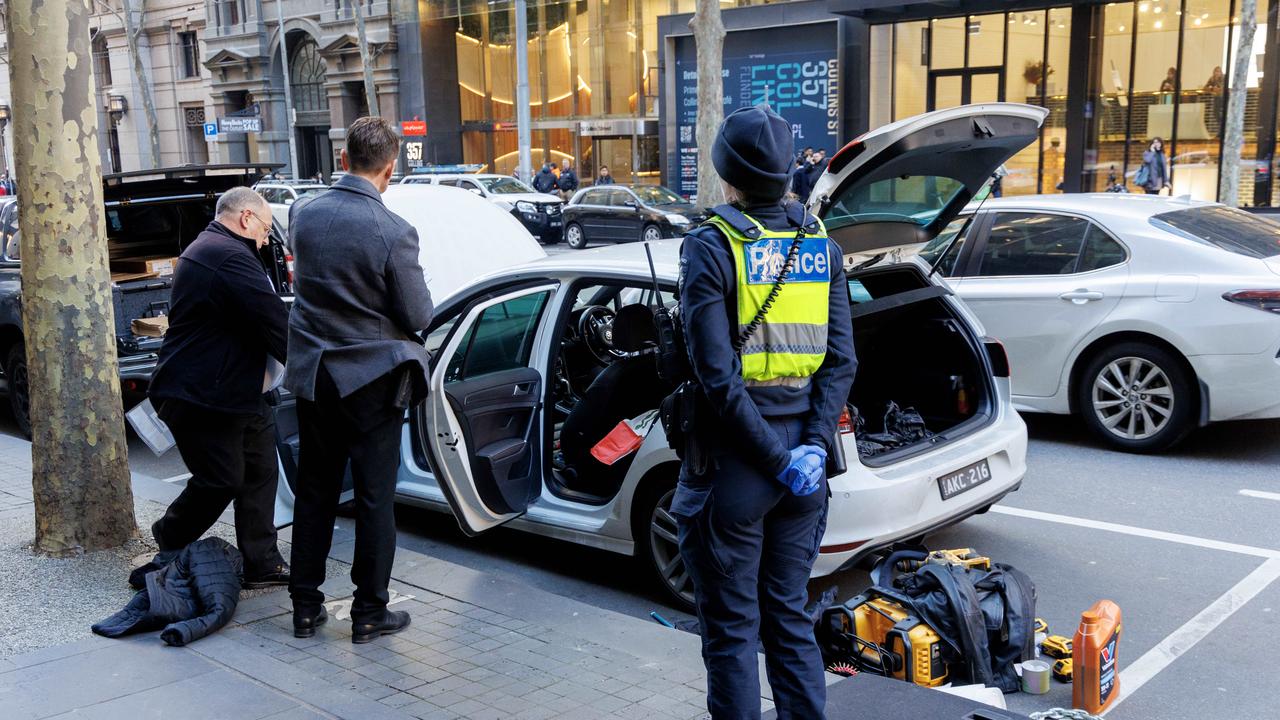 Police search a white Volkswagen after Collins St in Melbourne was placed into lockdown. Picture: David Geraghty