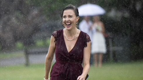 Marriage celebrant Alison Bartlett has had to juggle wedding cancellations throughout the COVID-19 pandemic and then the floods. Though some couples power through the wet weather. Photo: Simon Whittaker / En Vogue Wedding Photography.