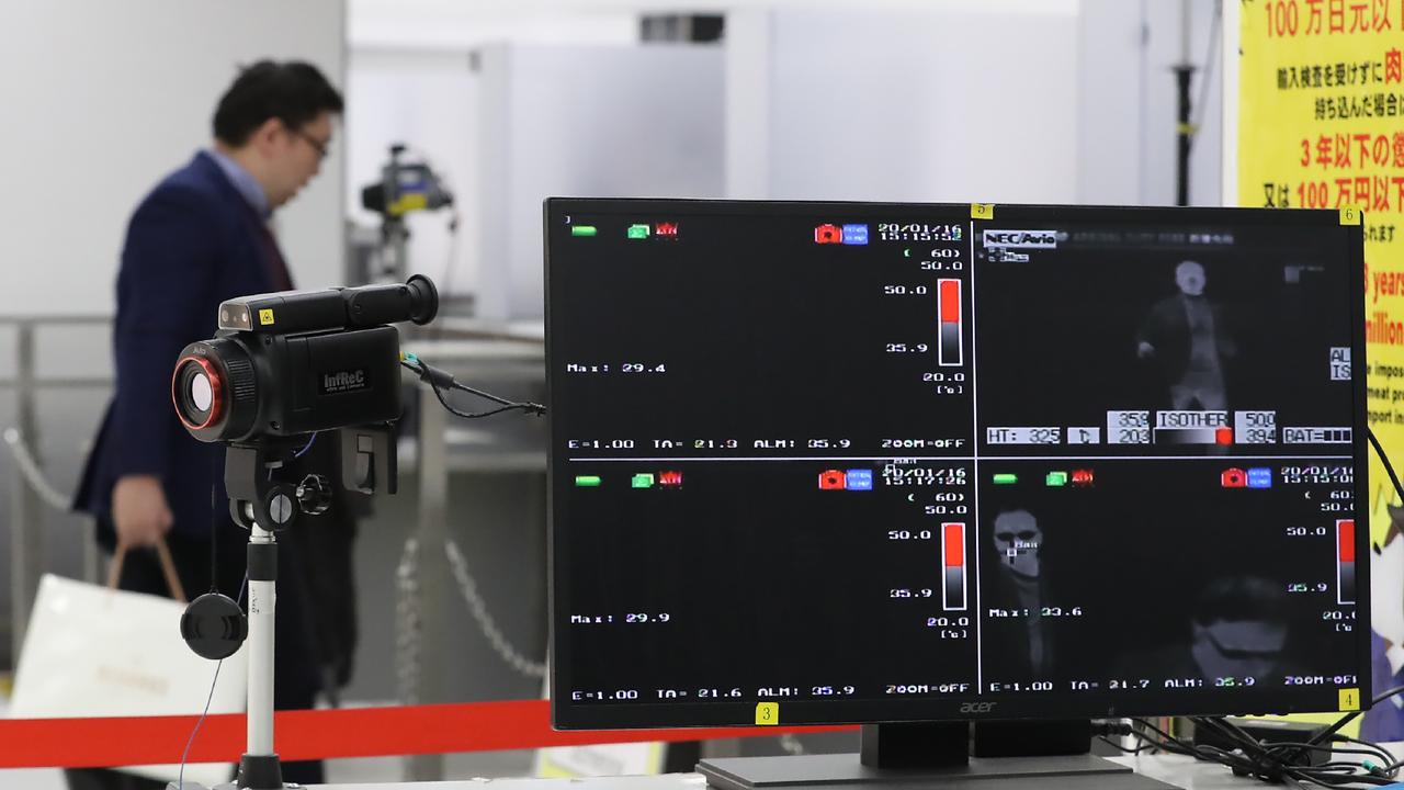 A quarantine station measures passenger body temperatures at Narita Airport after Japan’s first case of a mystery new virus. Picture: AFP