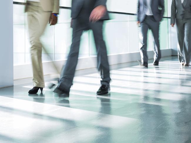 Group of business people walking on corridor.