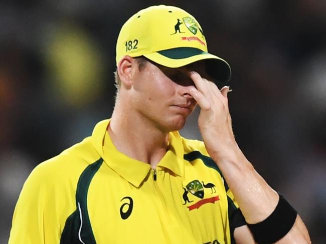 Australia's captian Steve Smith (C) reacts as Indian cricketers celebrate the wicket of Australia's Travis Head during the second one day international (ODI) match of the ongoing India-Australia cricket series at the Eden Gardens Cricket Stadium in Kolkata on September 21, 2017. / AFP PHOTO / Dibyangshu SARKAR / ----IMAGE RESTRICTED TO EDITORIAL USE - STRICTLY NO COMMERCIAL USE----- / GETTYOUT