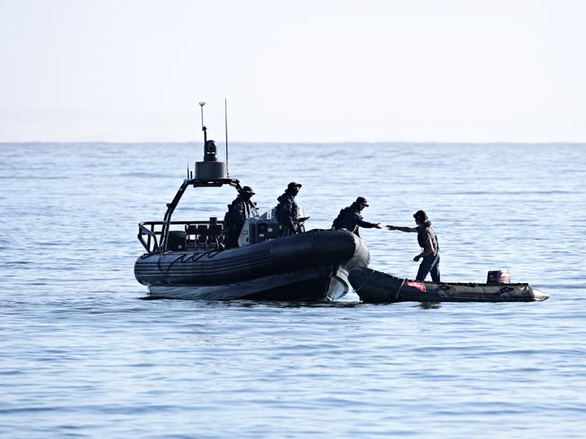 Police speak to a person on small boat at Newcastle harbour during the Newcastle Port protest. Picture: Adam Yip