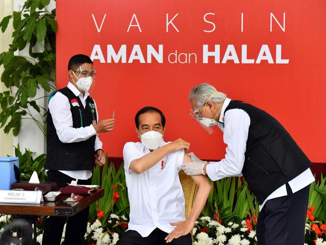 This handout photo taken and released on January 13, 2021 by Indonesia's Presidential Palace shows Indonesian President Joko Widodo (C) receiving the country's first Covid-19 vaccine jab at the Presidential Palace in Jakarta, kicking off a mass innoculation drive in a bid to control soaring case rates. (Photo by HANDOUT / Indonesia's Presidential Palace / AFP) / RESTRICTED TO EDITORIAL USE - MANDATORY CREDIT "AFP PHOTO / INDONESIA'S PRESIDENTIAL PALACE " - NO MARKETING - NO ADVERTISING CAMPAIGNS - DISTRIBUTED AS A SERVICE TO CLIENTS