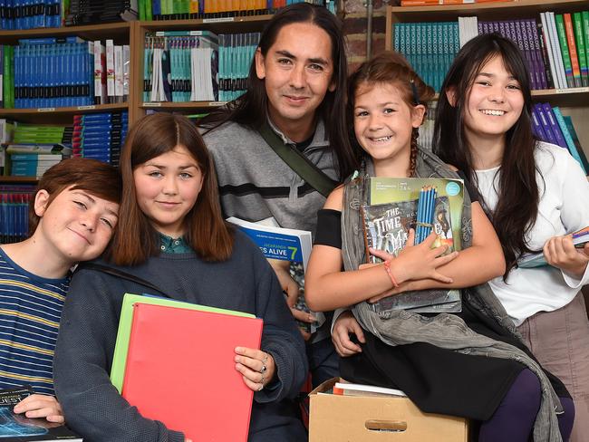 The Glenny family are struggling to cover the cost or both primary and secondary education this year. They are at the Les Twentyman Foundation headquarters with books and stationary. (L-R) Addicus (11), Celeste (14), David Glenny (dad), Uaria (11) and Lenoir (15). Picture: Josie Hayden