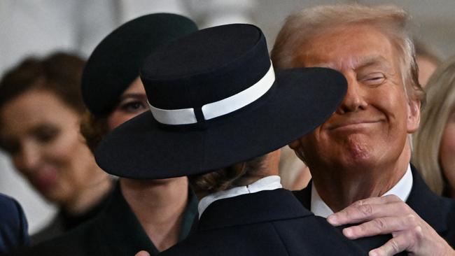 President Donald Trump could only get as far as the brim of his wife Melania’s hat allowed. Picture: AFP