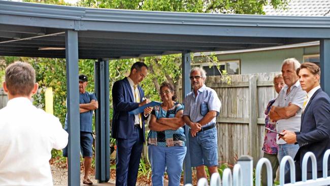 Ray White Buderim's Dan Smith and Jake Loiero continue to discuss bidding with clients at the auction of 18 Bellflower Rd, Sippy Downs. Picture: Erle Levey