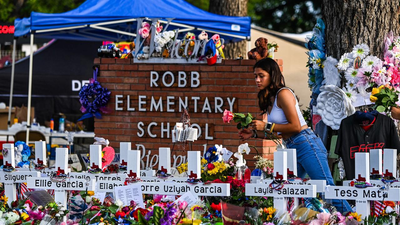 A woman lays flowers at a makeshift memorial at Robb Elementary School on May 28, 2022. Picture: Chandan Khanna / AFP.