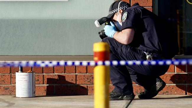 Police examine a petrol tin at the scene of the hair salon fire. Picture: AAP/MIKE BURTON