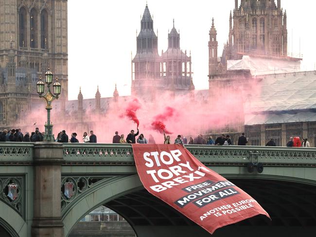 TOPSHOT - Anti-Brexit campaigners unfurl a banner on Westminster bridge on November 15, 2018 in front of the Houses of Parliament in London. - British Prime Minister Theresa May will give a press conference this afternoon amid intense criticism from lawmakers over her Brexit deal. (Photo by Adrian DENNIS / AFP)