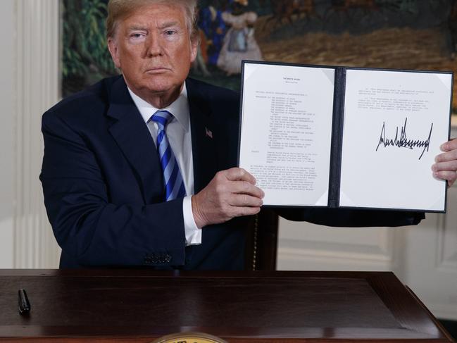 Donald Trump shows a signed Presidential Memorandum after announcing the US is to quit the Iran deal. Picture; AP.