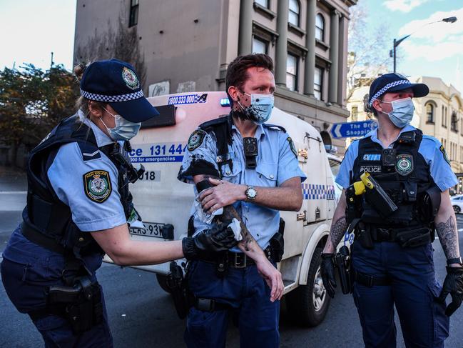 A police officer wipes away the paint thrown by a protester on her colleague in Sydney during last weekend’s protest. Picture: NCA NewsWire/Flavio Brancaleone