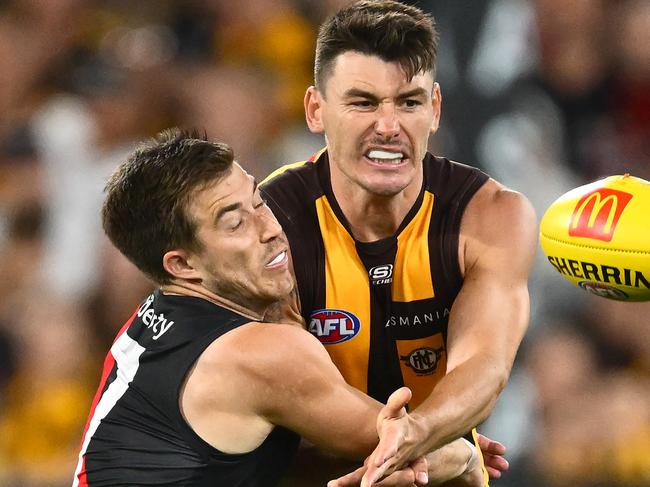 MELBOURNE, AUSTRALIA - MARCH 14: Josh Battle of the Hawks handballs whilst being tackled by Zach Merrett of the Bombers during the round one AFL match between Hawthorn Hawks and Essendon Bombers at Melbourne Cricket Ground, on March 14, 2025, in Melbourne, Australia. (Photo by Quinn Rooney/Getty Images)