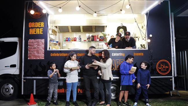 Nawaf Refai and his wife Sarah run the 2 Smokin Arabs food truck in the driveway of their Punchbowl home, where the Abraham family are collecting dinner. Picture: Sam Ruttyn