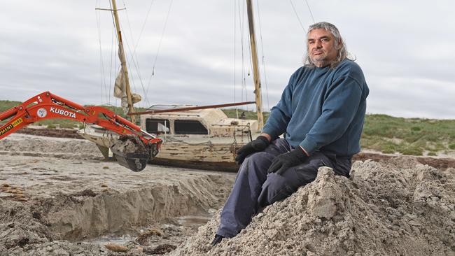 Claude Evans with his yacht that is stranded on the beach at North Haven. Picture: Tom Huntley