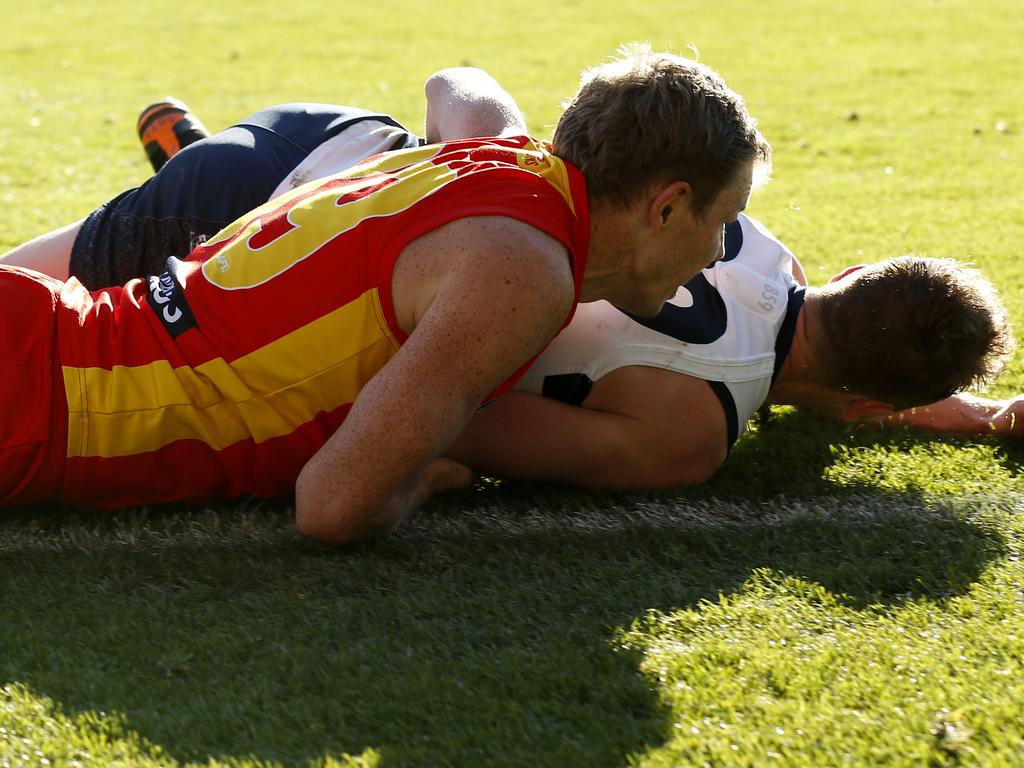 Nick Holman of the Suns tackles Mitch Duncan.