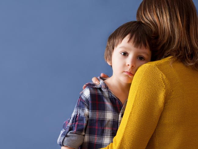 Sad little child, boy, hugging his mother at home, isolated image, copy space. Family concept