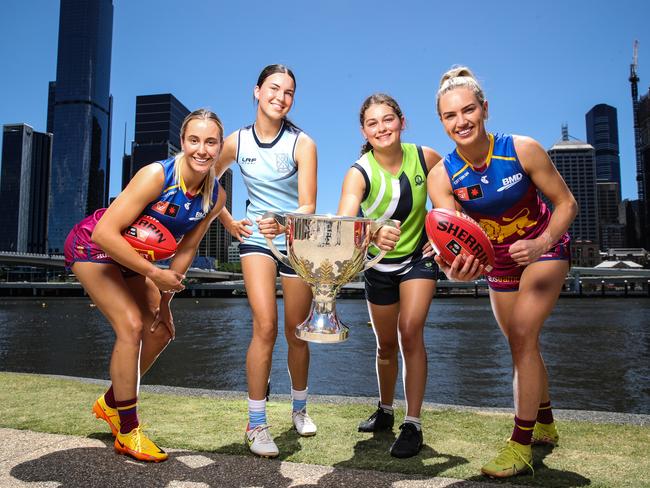 Brisbane Lions AFLW players Nat Grider and Orla O'Dwyer alongside aussie rules players from Ipswich Girls Grammar School, Mia Piantoni, 14 and from Summerville House, Isabella Wheeler, 16 as they hold the premiership cup.  Picture: zak Simmonds