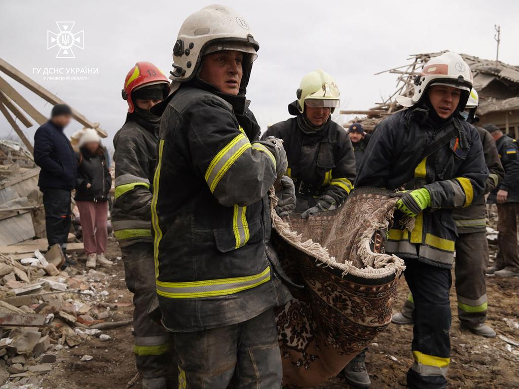 Ukrainian Emergency Service rescuers carrying body of a man following a Russian missile strike. Picture: AFP