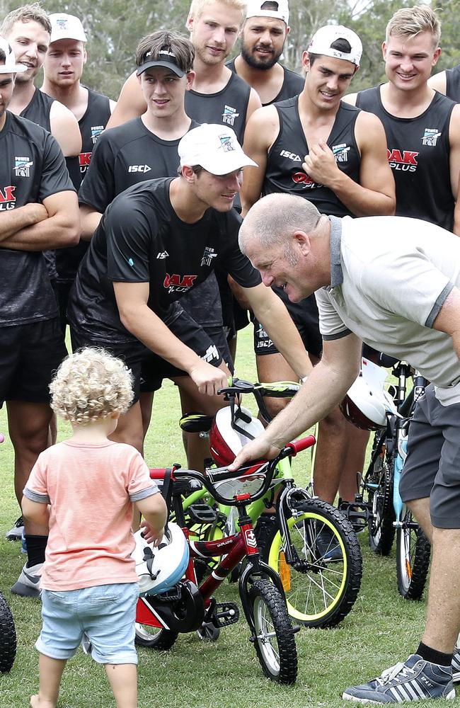 Players hand a bike they built to one of the children at the training camp. Picture: Sarah Reed.