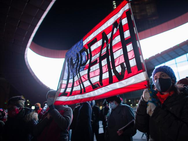 Demonstrators hold a banner calling for impeachment of US President Donald Trump. Picture: AFP