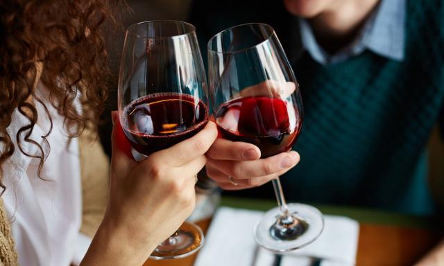 Amorous couple toasting with red wine in restaurant